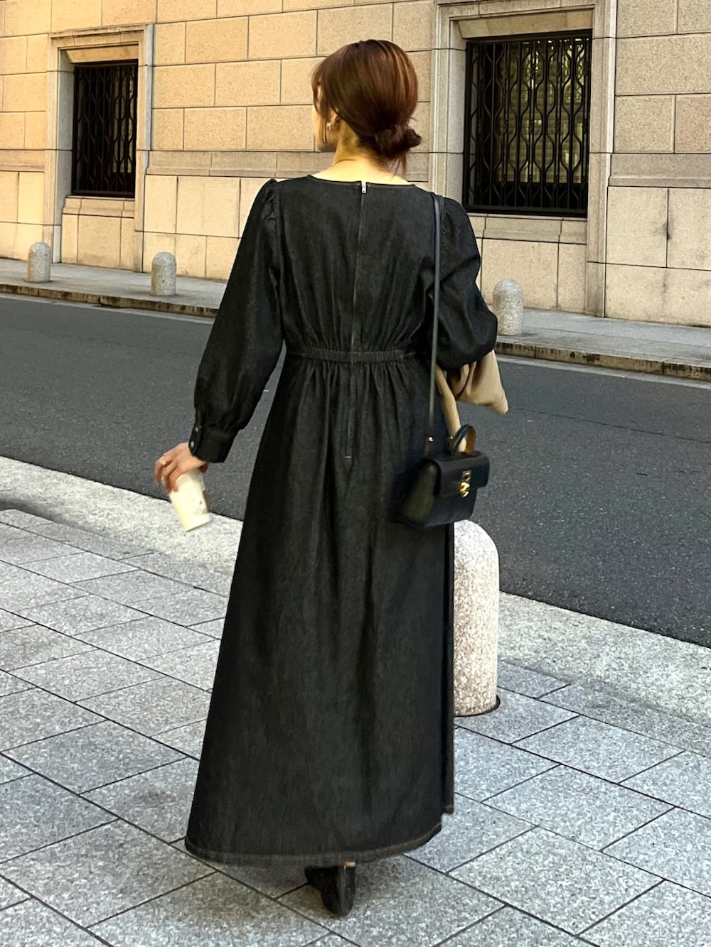ブラック系のワンピース、ブラック系のパンプス、ベージュ系のステンカラーコートを着用したレディースの冬コーディネートの5枚目の写真