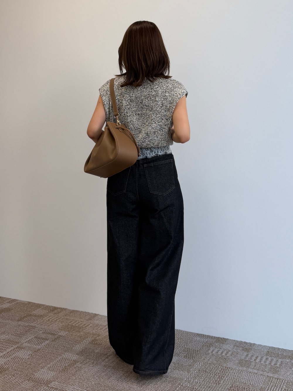ブラック系のデニムパンツ、ブラック系のパンプス、ベージュ系のニット/セーターを着用したレディースの夏コーディネートの4枚目の写真