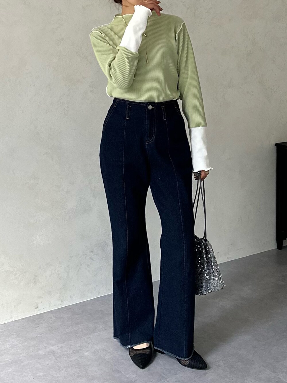 ブルー系のデニムパンツ、グレー系のトートバッグ、グリーン系のTシャツ/カットソーを着用したレディースの冬コーディネートの3枚目の写真