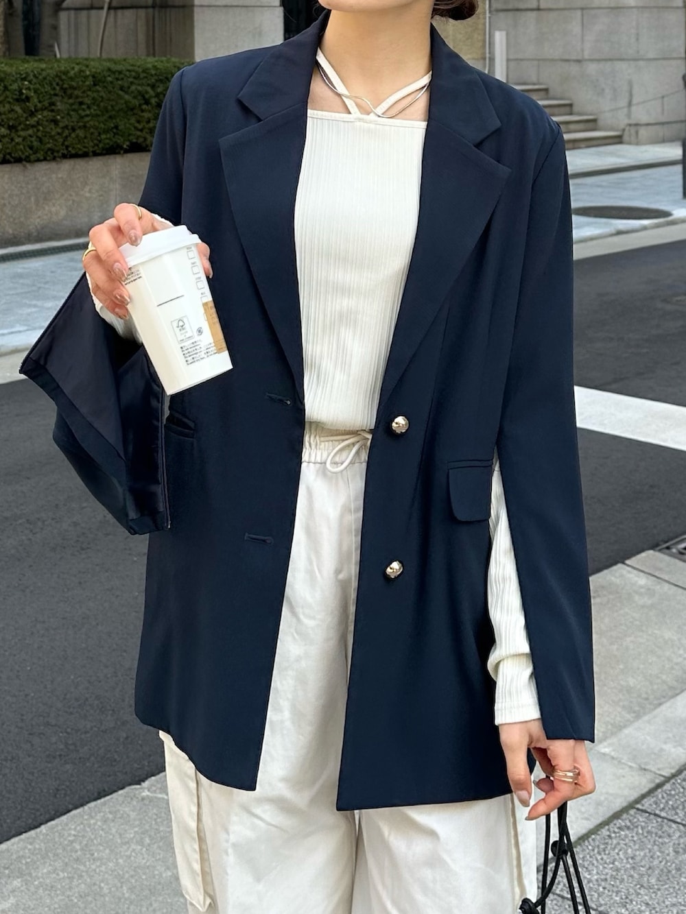 ブルー系のテーラードジャケット、ブラック系のトートバッグ、ブラック系のパンプスを着用したレディースの冬コーディネートの4枚目の写真