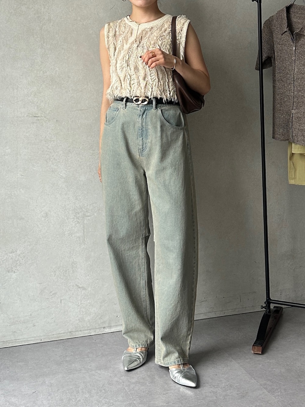 ブルー系のデニムパンツ、ホワイト系のニット/セーター、ブラック系のパンプスを着用したレディースの夏コーディネートの2枚目の写真