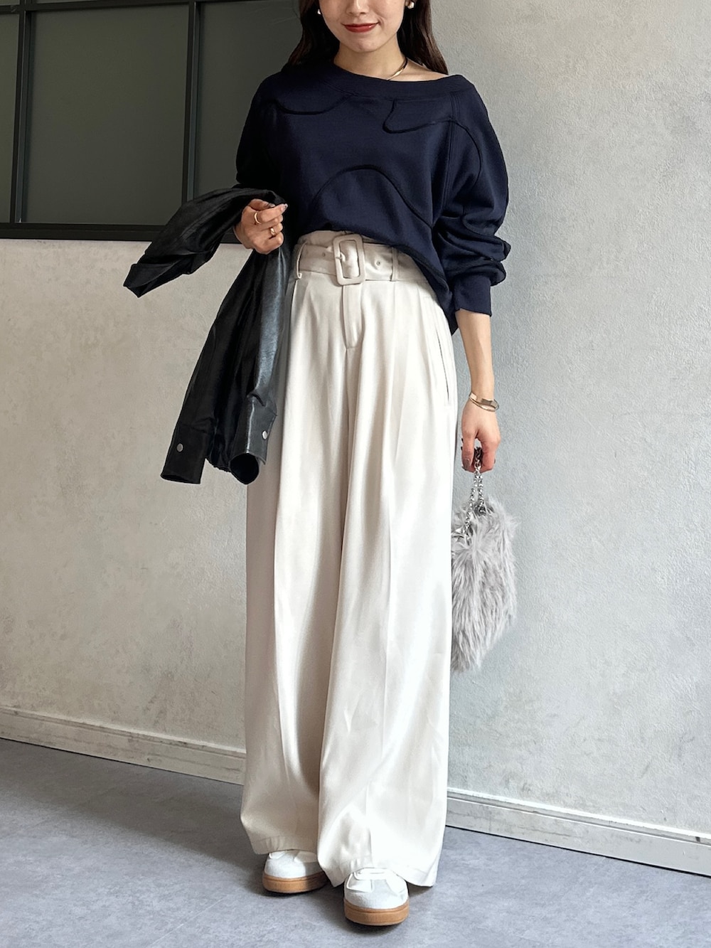 ブルー系のTシャツ/カットソー、ホワイト系のスラックス、ベージュ系のショルダーバッグを着用したレディースの冬コーディネートの2枚目の写真