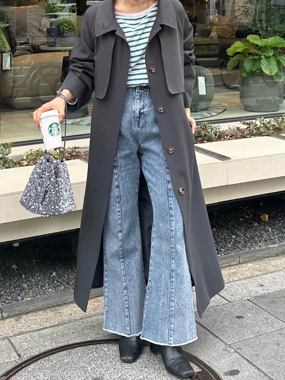 ブルー系のデニムパンツ、グレー系のトートバッグ、グレー系のステンカラーコートを着用したレディースの冬コーディネートの3枚目の写真