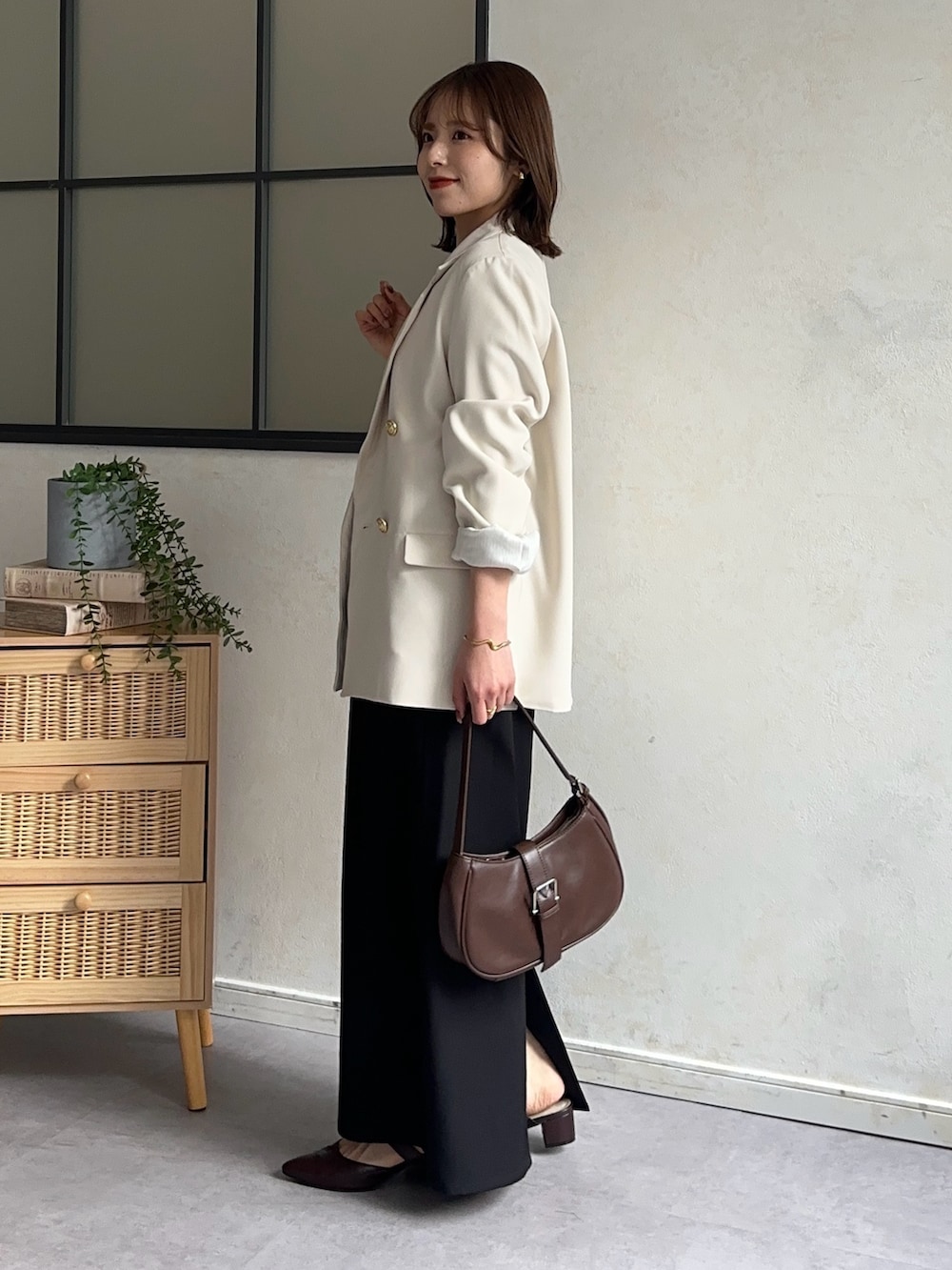 ホワイト系のテーラードジャケット、ブラック系のスカート、ブラウン系のパンプスを着用したレディースの冬コーディネートの3枚目の写真