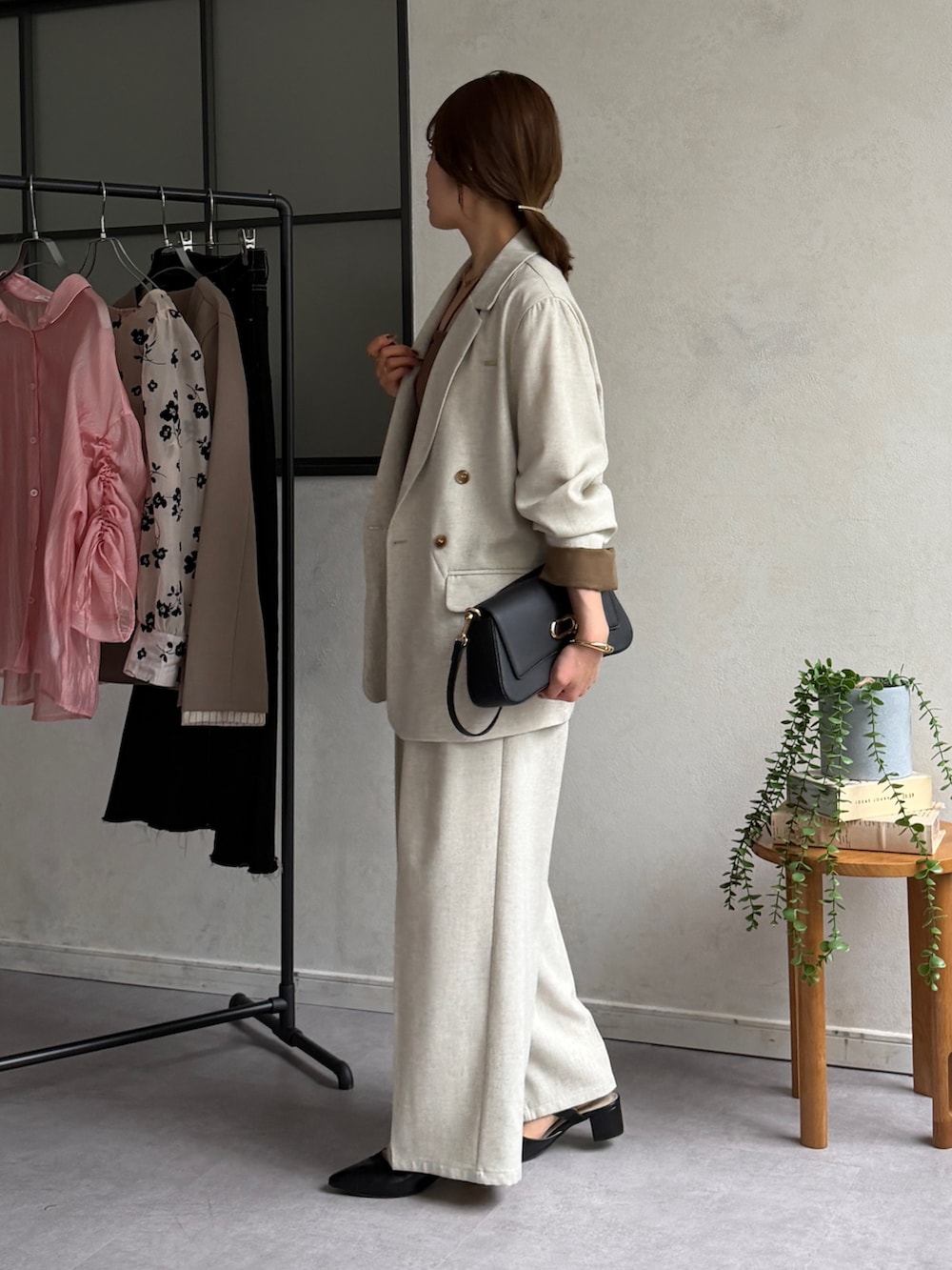 ベージュ系のテーラードジャケット、ホワイト系のスラックス、ブラック系のパンプスを着用したレディースの春コーディネートの3枚目の写真