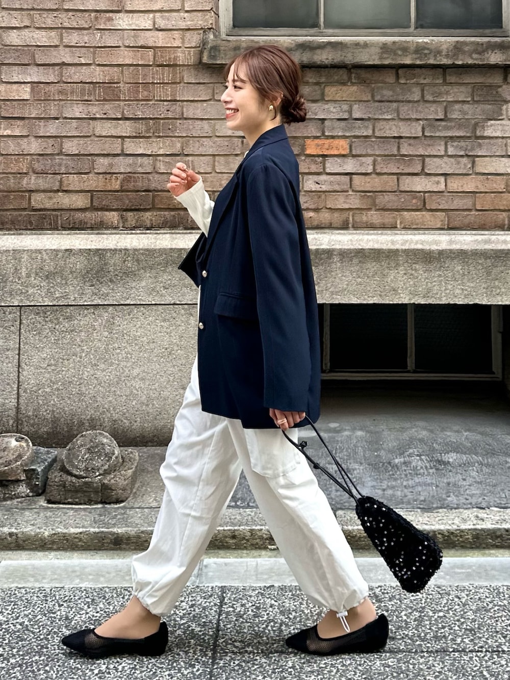 ブルー系のテーラードジャケット、ブラック系のトートバッグ、ブラック系のパンプスを着用したレディースの冬コーディネートの3枚目の写真