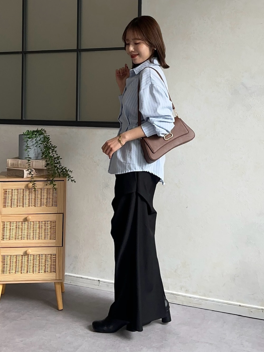 ブラック系のスカート、ブルー系のシャツ/ブラウス、ブラウン系のショルダーバッグを着用したレディースの冬コーディネートの3枚目の写真