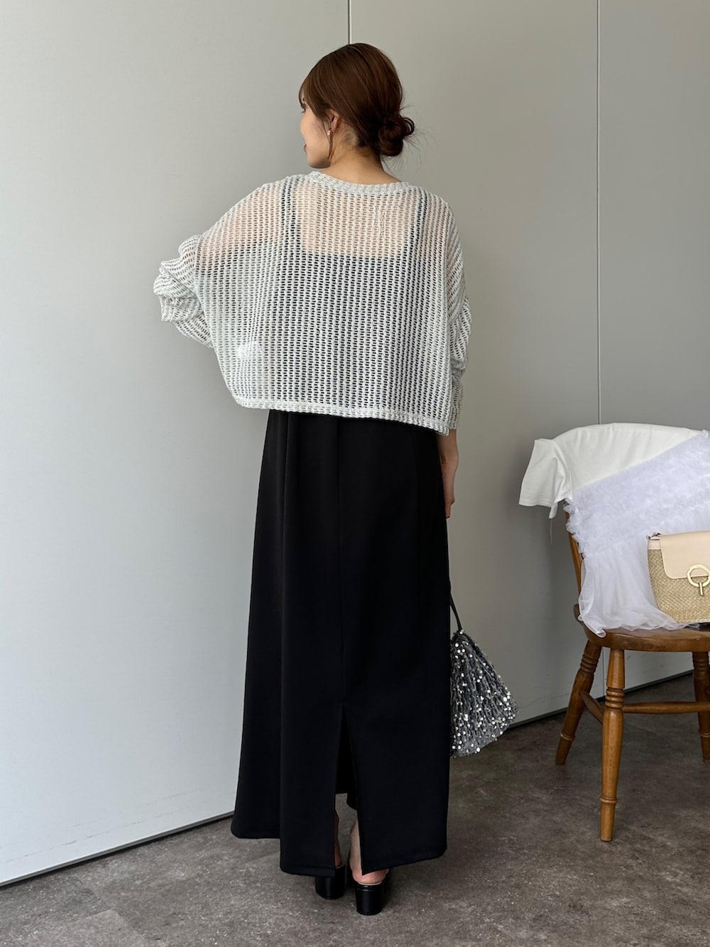 グリーン系のニット/セーター、ブラック系のサンダル、グレー系のトートバッグを着用したレディースの春コーディネートの3枚目の写真