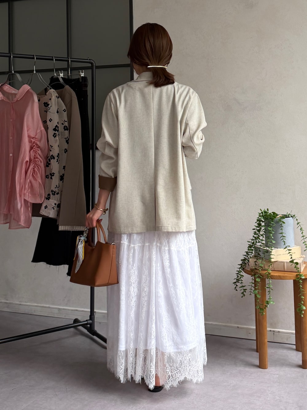 ホワイト系のスカート、ブラウン系のサンダル、ブラック系のTシャツ/カットソーを着用したレディースの春コーディネートの3枚目の写真