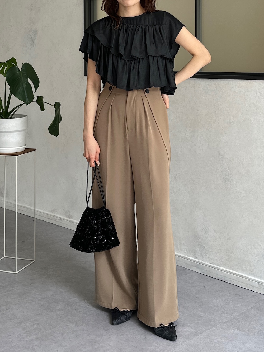 ブラック系のシャツ/ブラウス、ベージュ系のスラックス、ブラック系のトートバッグを着用したレディースの春コーディネートの4枚目の写真