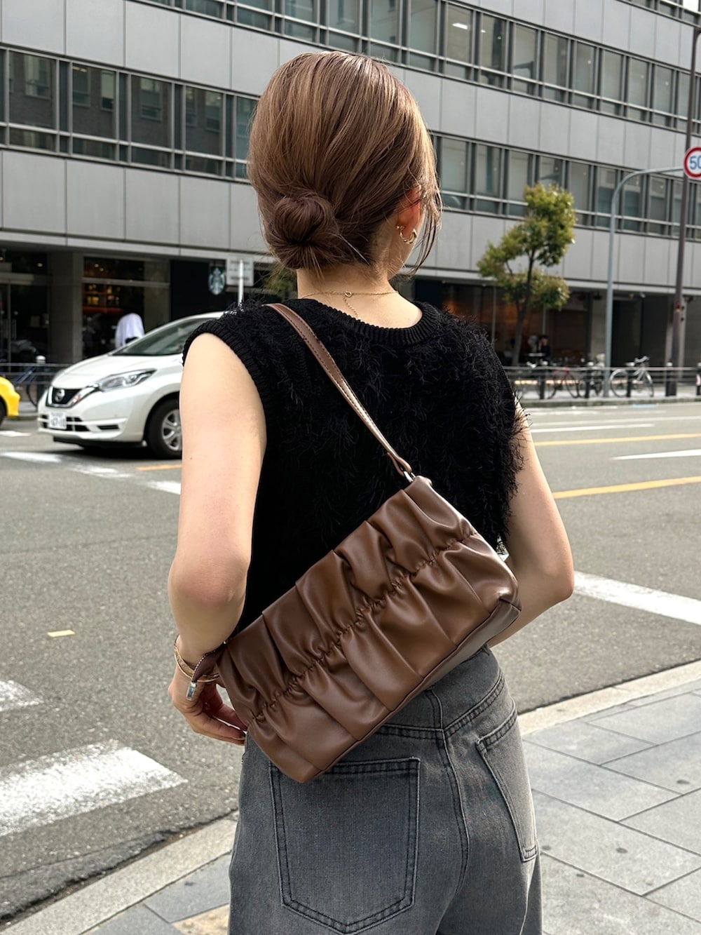 ブラック系のデニムパンツ、ブラック系のパンプス、ブラック系のニット/セーターを着用したレディースの春コーディネートの4枚目の写真