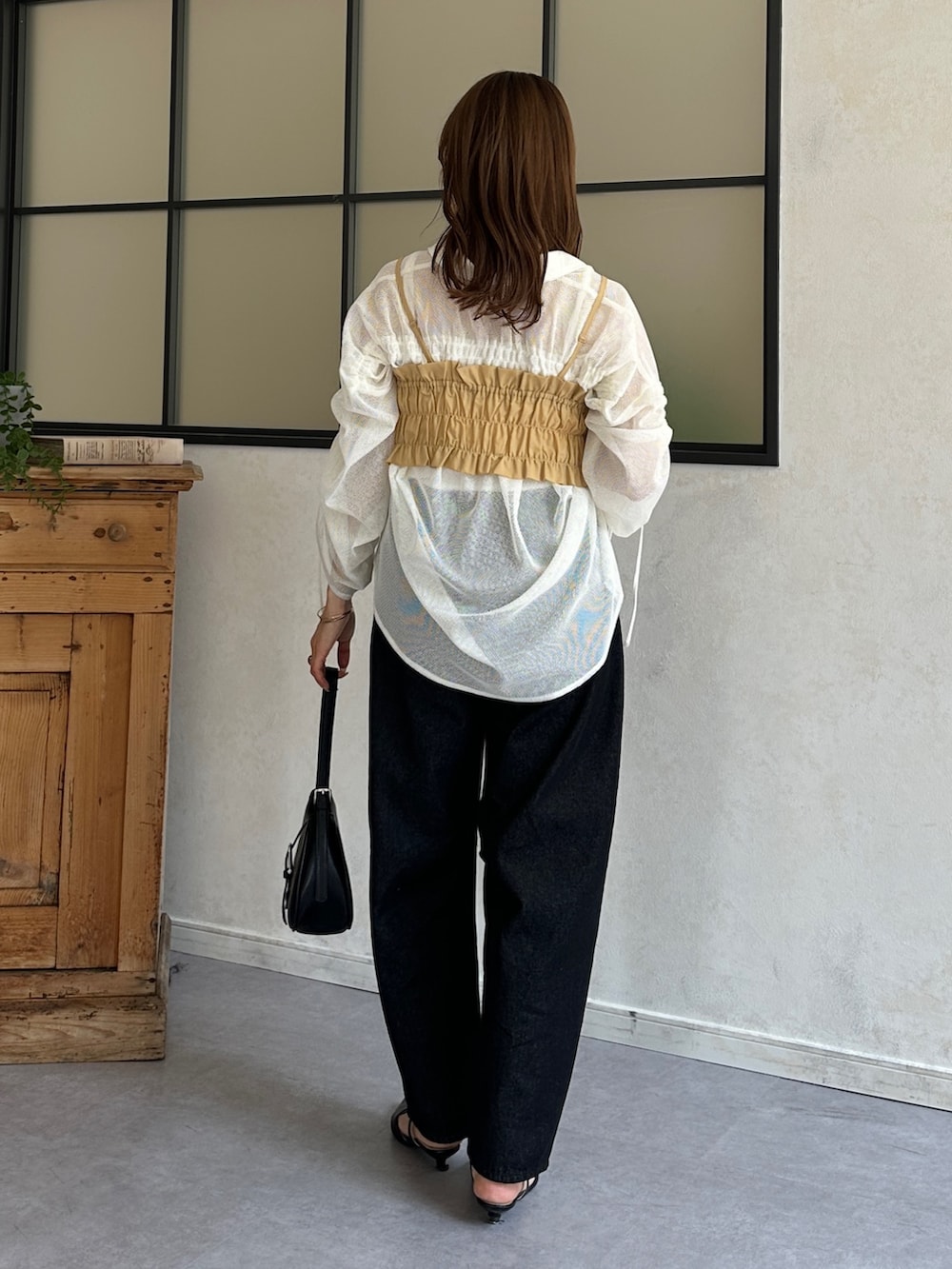 ブルー系のデニムパンツ、ブラック系のパンプス、ホワイト系のシャツ/ブラウスを着用したレディースの春コーディネートの4枚目の写真