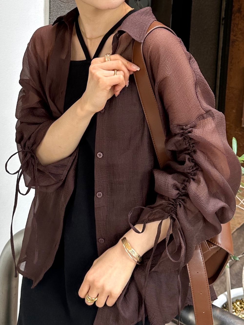 ブラック系のワンピース、ブラウン系のシャツ/ブラウス、ブラウン系のショルダーバッグを着用したレディースの夏コーディネートの3枚目の写真