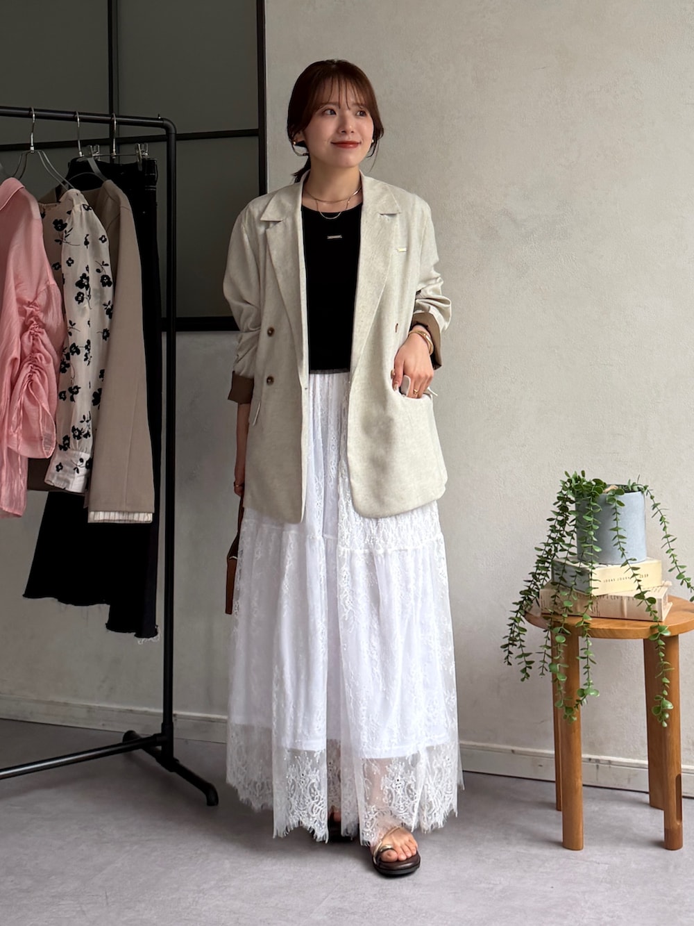 ホワイト系のスカート、ブラウン系のサンダル、ブラック系のTシャツ/カットソーを着用したレディースの春コーディネートの4枚目の写真