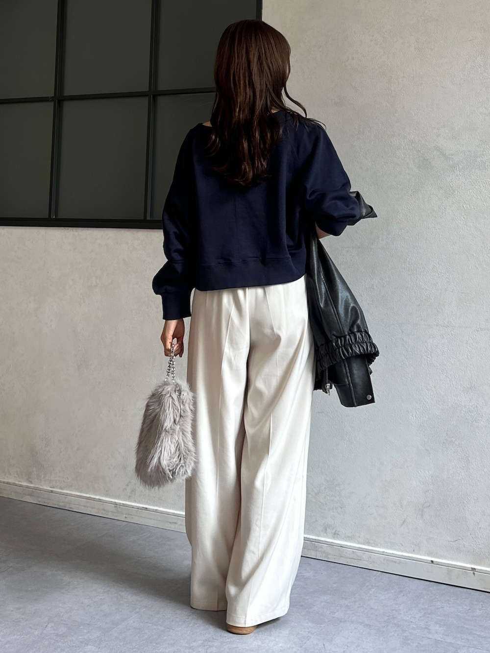 ブルー系のTシャツ/カットソー、ホワイト系のスラックス、ベージュ系のショルダーバッグを着用したレディースの冬コーディネートの4枚目の写真