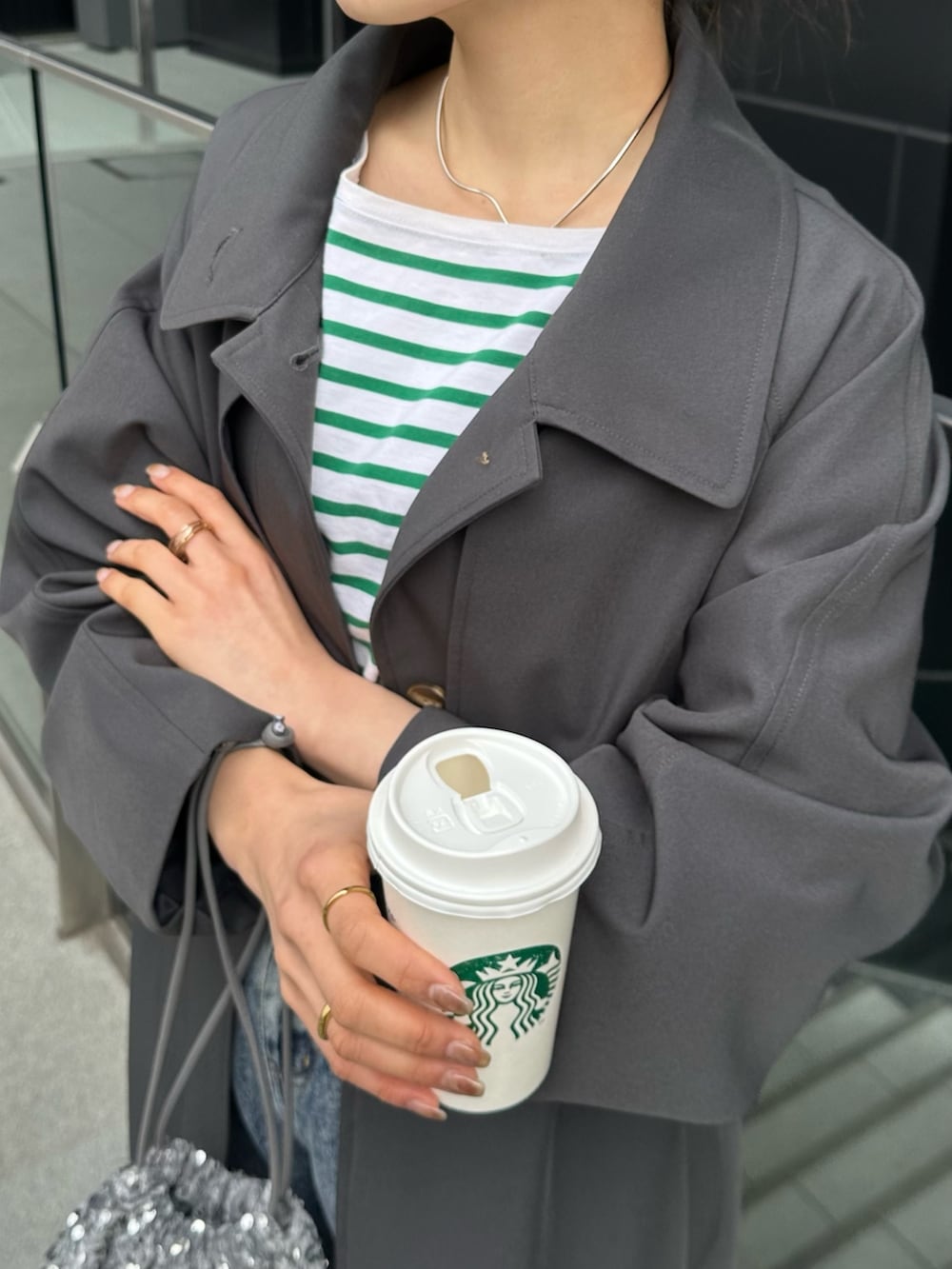 ブルー系のデニムパンツ、グレー系のトートバッグ、グレー系のステンカラーコートを着用したレディースの冬コーディネートの6枚目の写真