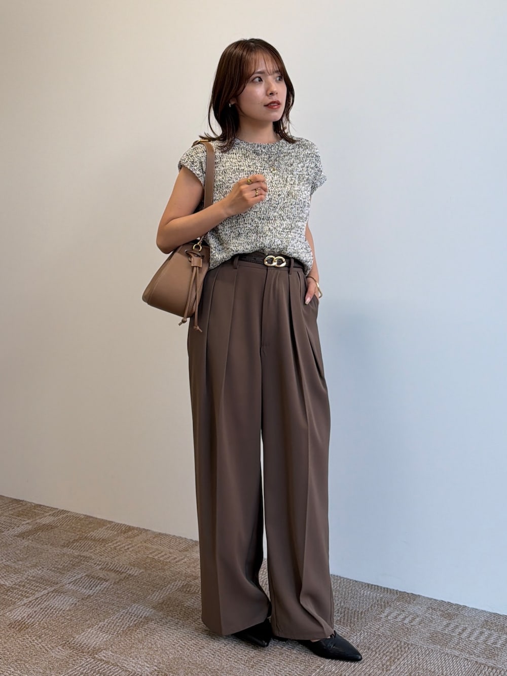 ベージュ系のニット/セーター、ブラック系のパンプス、ブラウン系のスラックスを着用したレディースの夏コーディネートの4枚目の写真