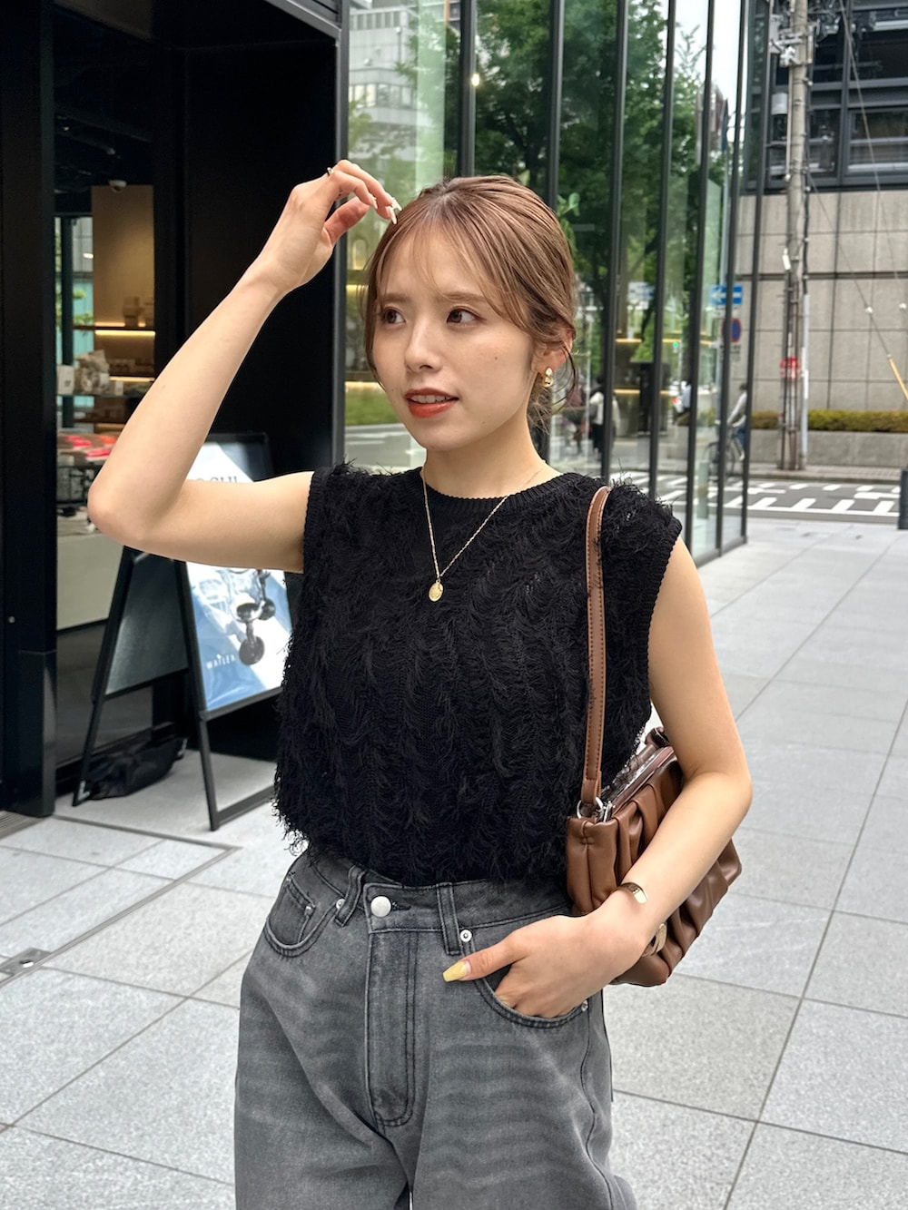 ブラック系のデニムパンツ、ブラック系のパンプス、ブラック系のニット/セーターを着用したレディースの春コーディネートの2枚目の写真