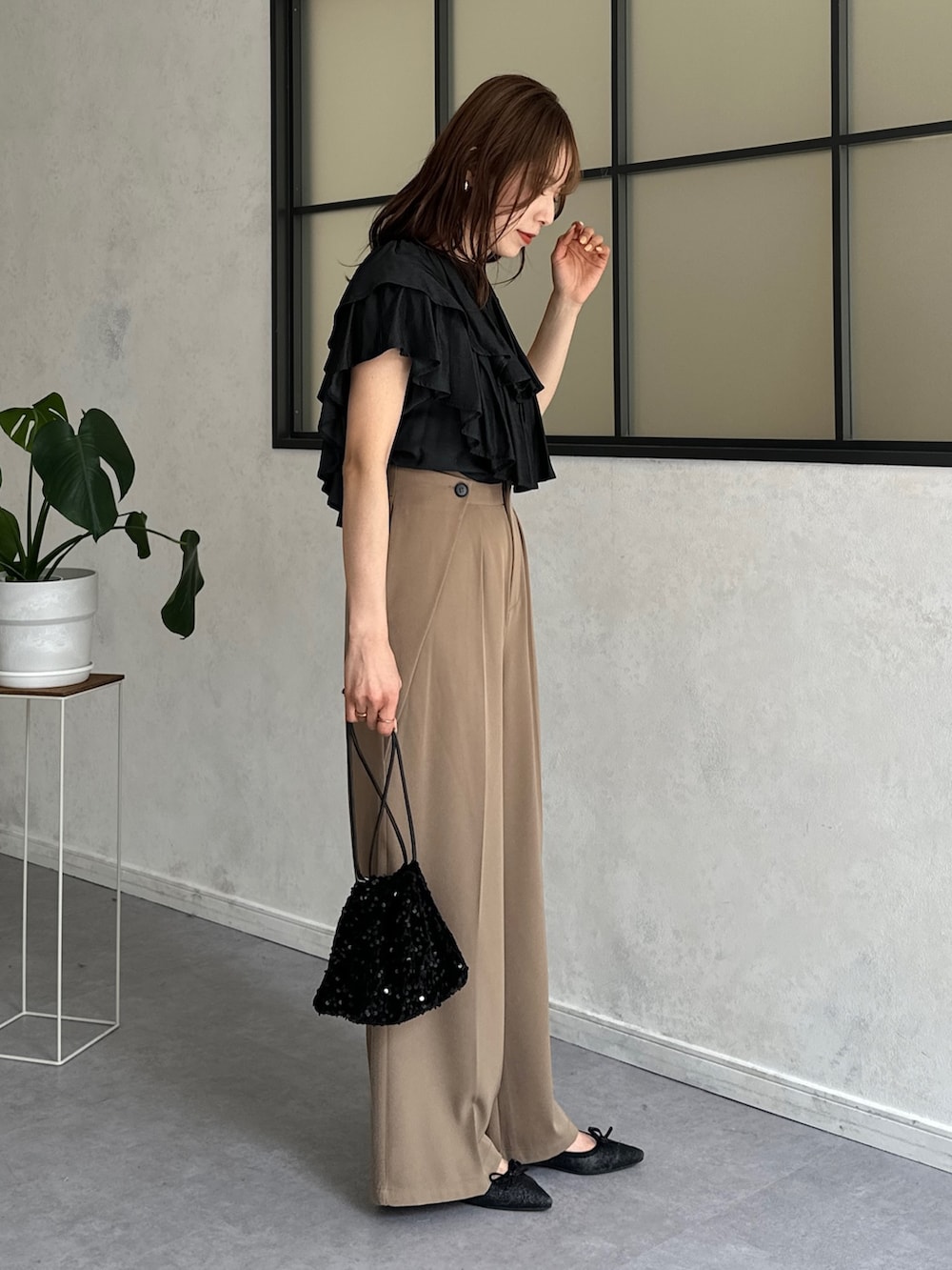 ブラック系のシャツ/ブラウス、ベージュ系のスラックス、ブラック系のトートバッグを着用したレディースの春コーディネートの3枚目の写真