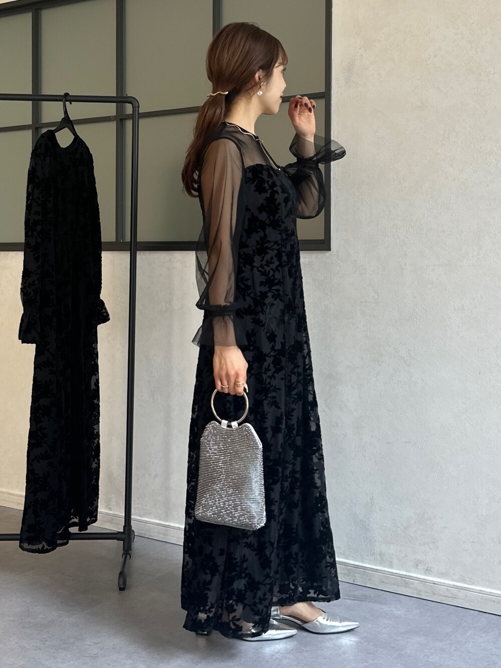 ブラック系のワンピース、シルバー系のトートバッグ、シルバー系のパンプスを着用したレディースの冬コーディネートの5枚目の写真