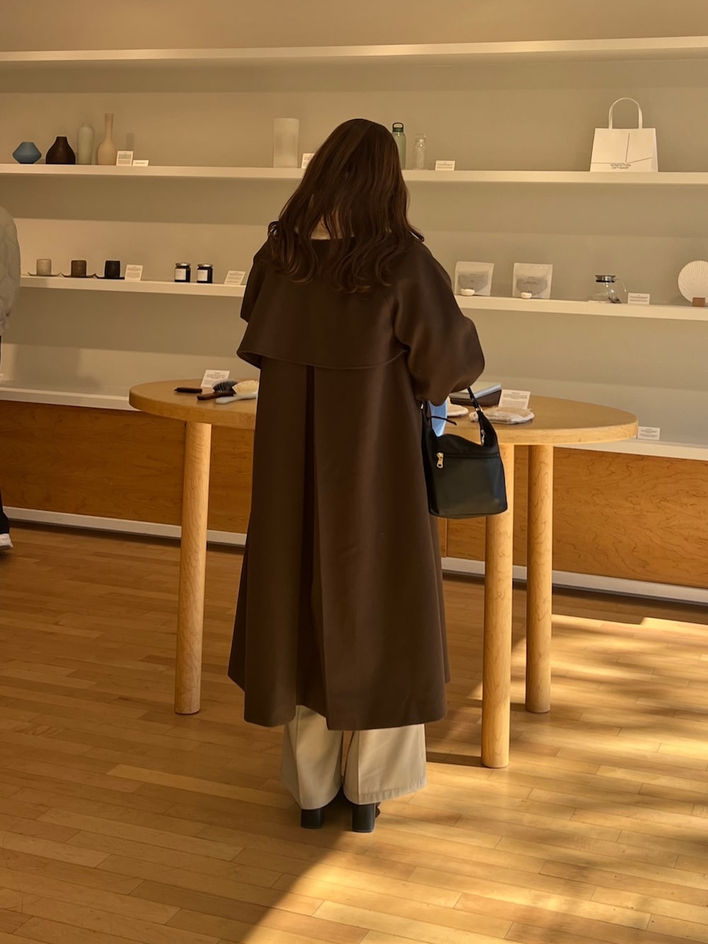 ブラウン系のその他アウター、ベージュ系のスラックス、ホワイト系のニット/セーターを着用したレディースの冬コーディネートの4枚目の写真