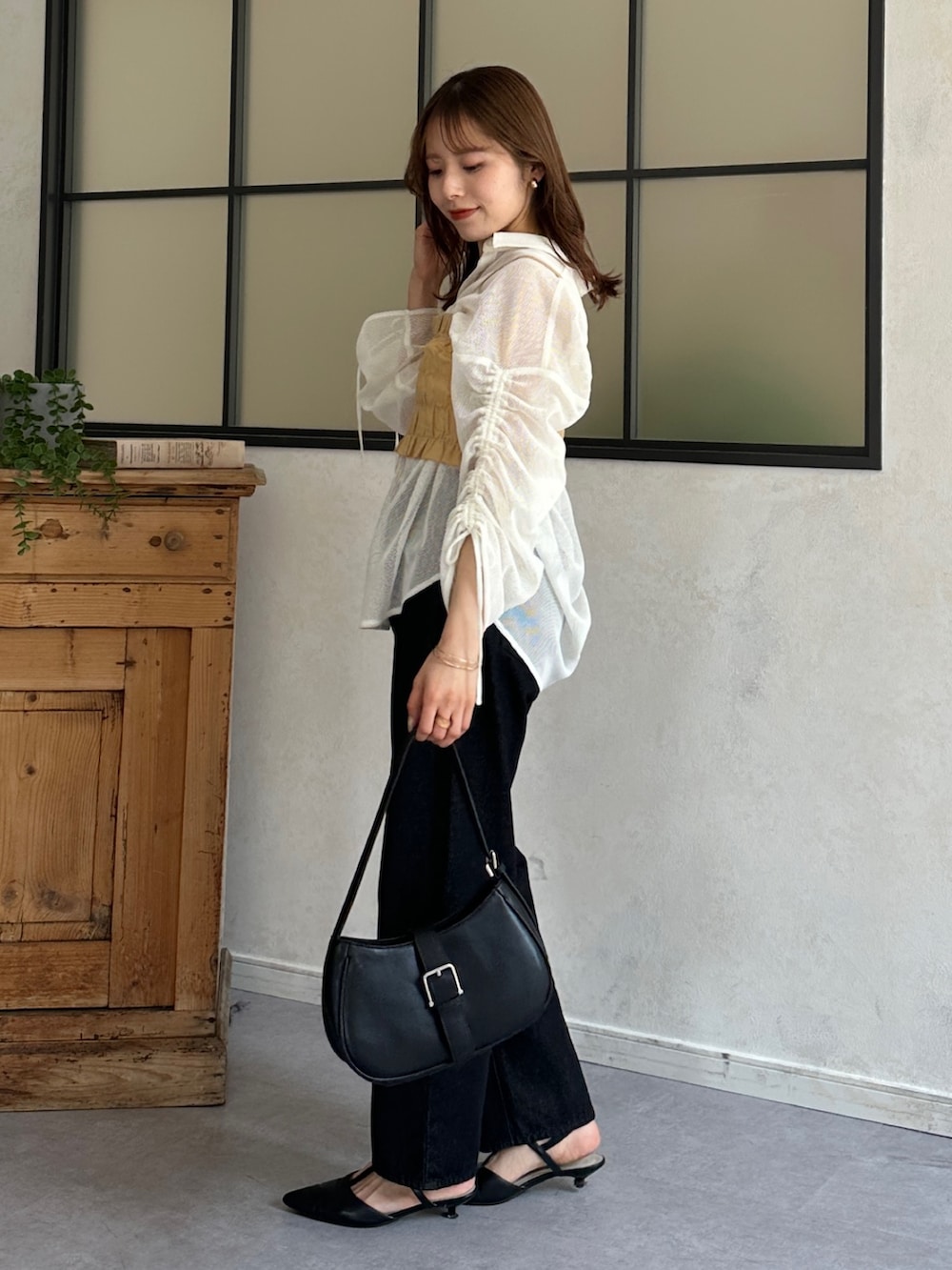 ブルー系のデニムパンツ、ブラック系のパンプス、ホワイト系のシャツ/ブラウスを着用したレディースの春コーディネートの3枚目の写真