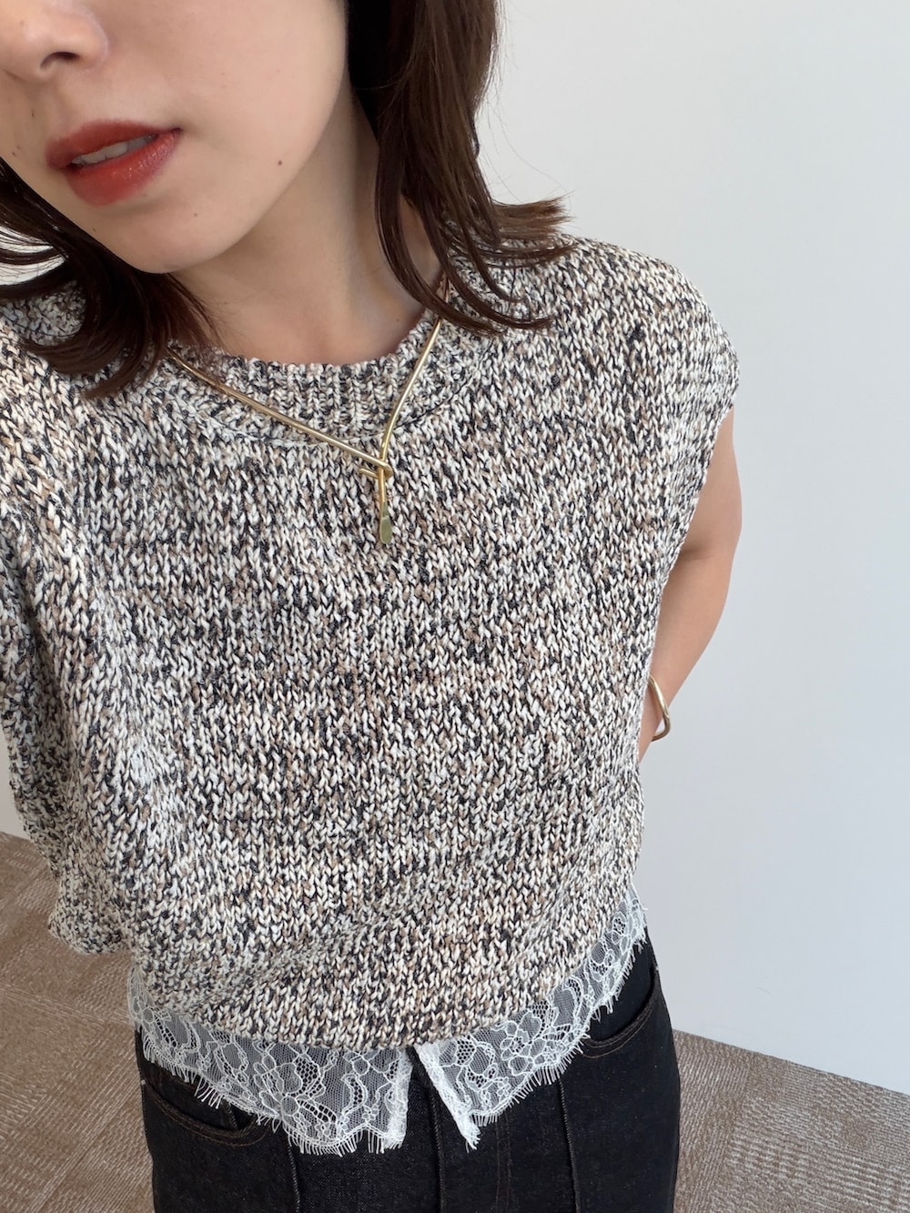 ブラック系のデニムパンツ、ブラック系のパンプス、ベージュ系のニット/セーターを着用したレディースの夏コーディネートの2枚目の写真