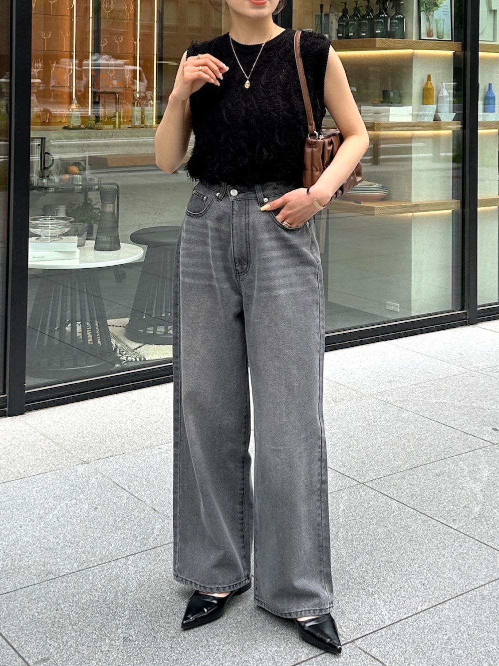 ブラック系のデニムパンツ、ブラック系のパンプス、ブラック系のニット/セーターを着用したレディースの春コーディネートの3枚目の写真