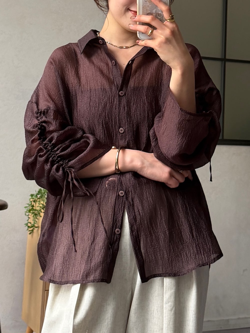 ブラウン系のシャツ/ブラウス、ブラック系のパンプス、ホワイト系のスラックスを着用したレディースの春コーディネートの4枚目の写真