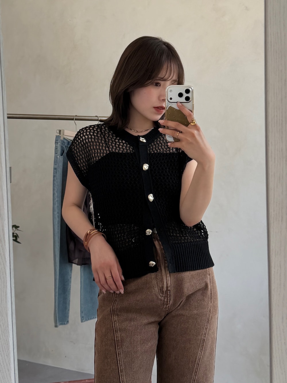 ブラック系のカーディガン/ボレロ、ブラウン系のデニムパンツを着用したレディースの夏コーディネートの2枚目の写真
