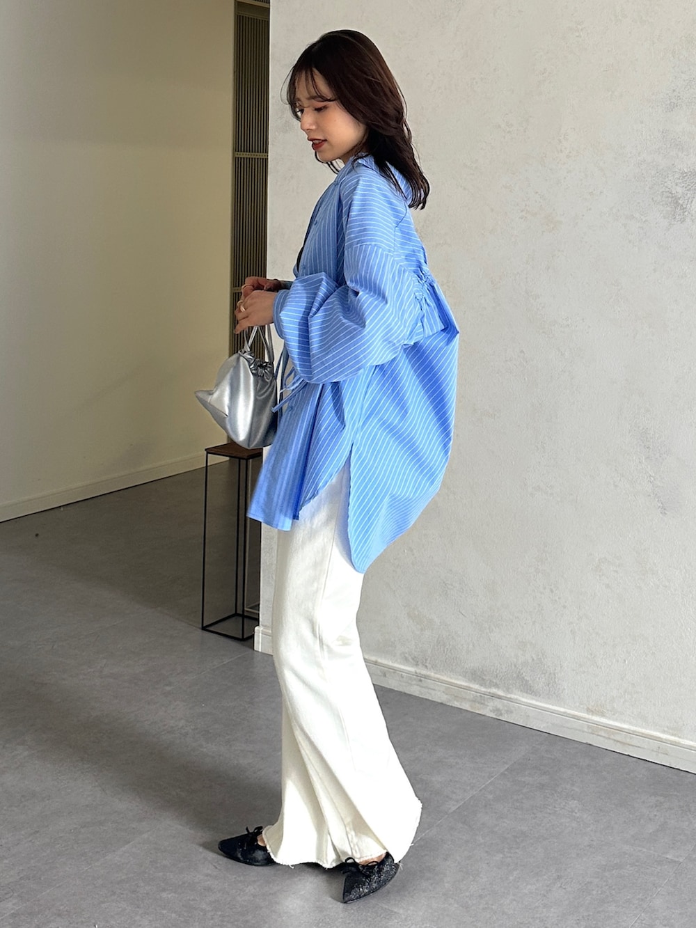 ブルー系のシャツ/ブラウス、ブラック系のパンプスを着用したレディースの春コーディネートの2枚目の写真