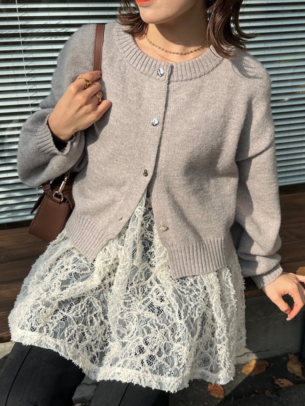 グレー系のカーディガン/ボレロ、ホワイト系のチュニック、ブラウン系のショルダーバッグを着用したレディースの冬コーディネートの3枚目の写真