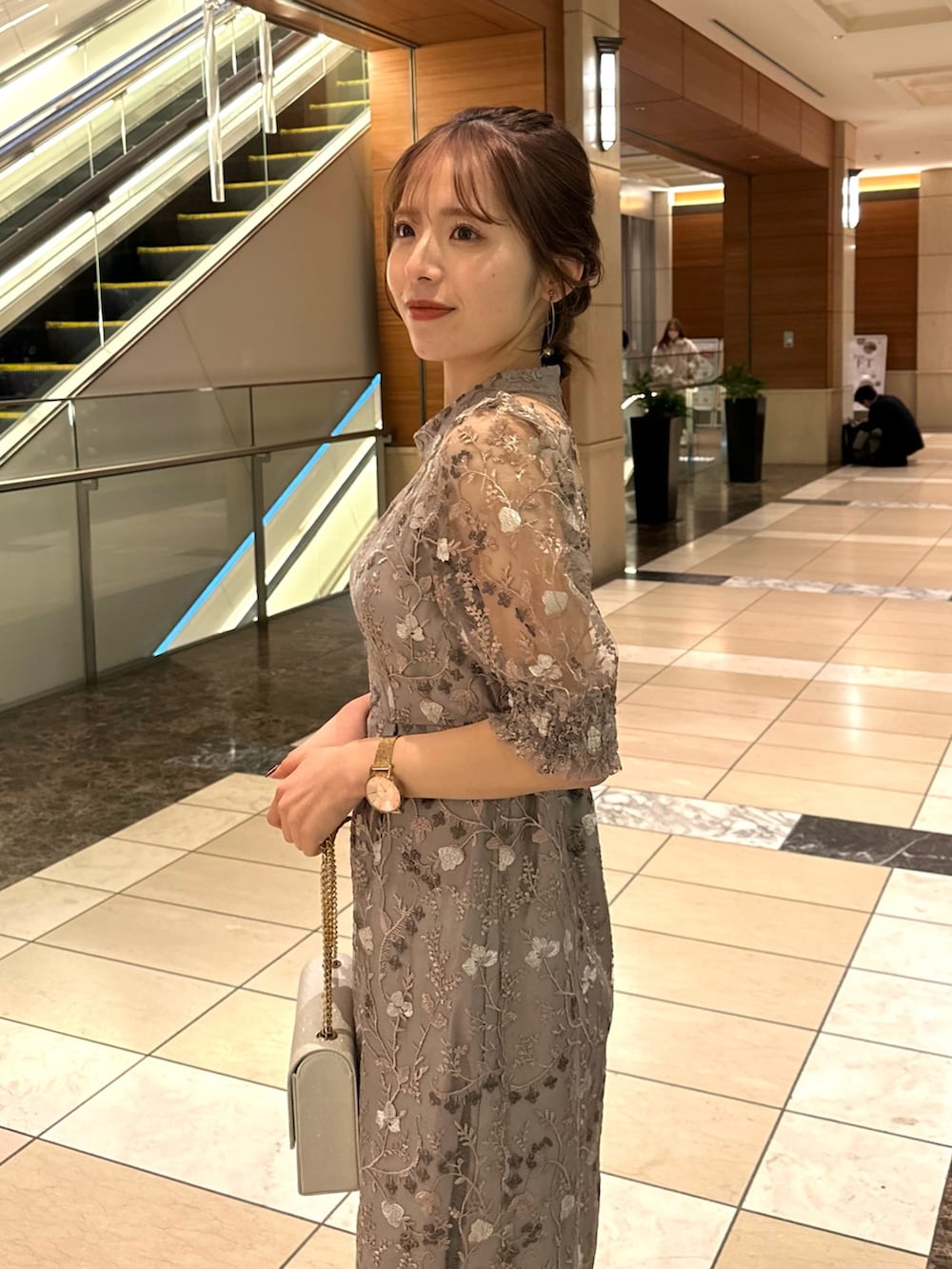 ピンク系のドレス、ベージュ系のハンドバッグを着用したレディースの冬コーディネートの2枚目の写真