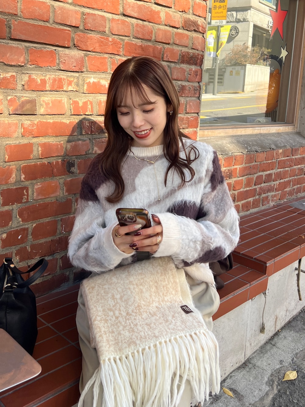 ブラウン系のその他アウター、ベージュ系のスラックス、ホワイト系のニット/セーターを着用したレディースの冬コーディネートの2枚目の写真