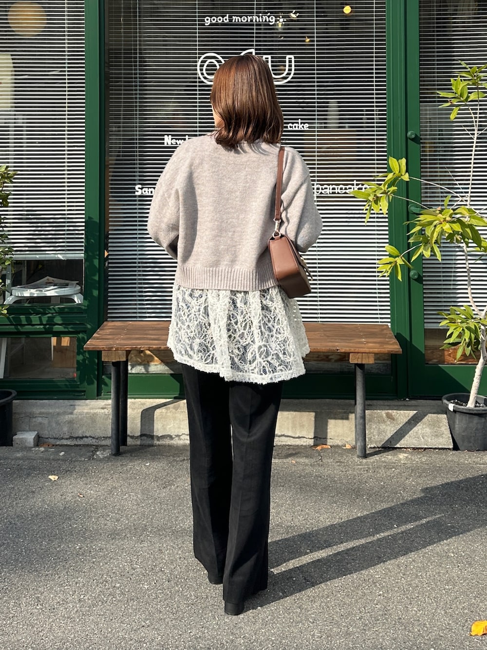 グレー系のカーディガン/ボレロ、ホワイト系のチュニック、ブラウン系のショルダーバッグを着用したレディースの冬コーディネートの4枚目の写真