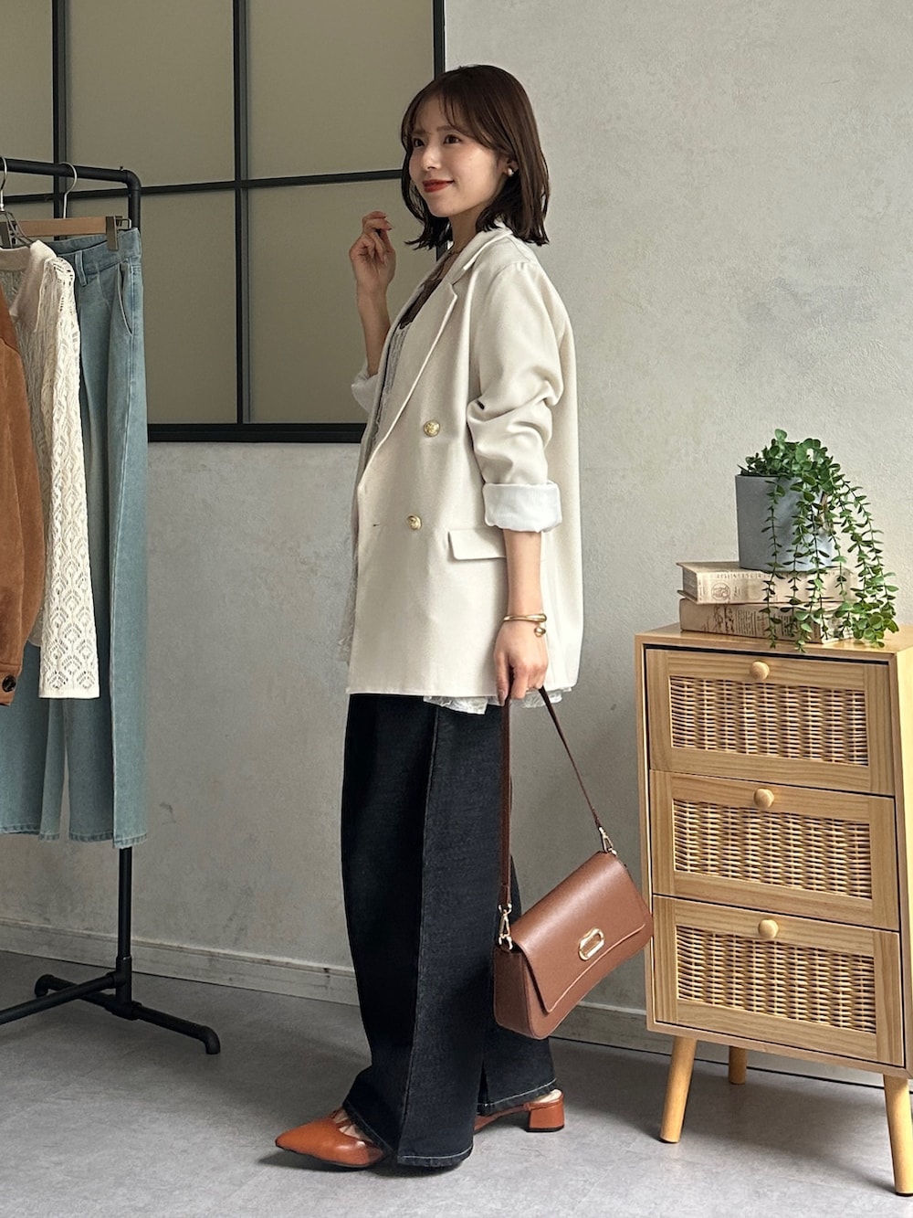 ホワイト系のテーラードジャケット、ブラック系のデニムパンツ、オレンジ系のパンプスを着用したレディースの冬コーディネートの2枚目の写真