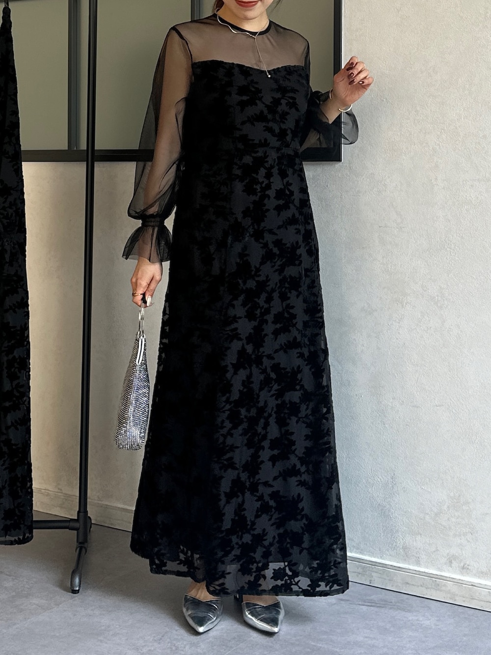 ブラック系のワンピース、シルバー系のトートバッグ、シルバー系のパンプスを着用したレディースの冬コーディネートの2枚目の写真