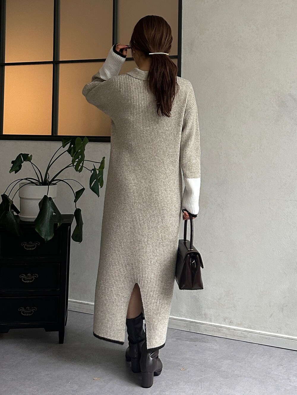 ベージュ系のワンピース、レッド系のショルダーバッグ、ブラウン系のブーツを着用したレディースの冬コーディネートの3枚目の写真