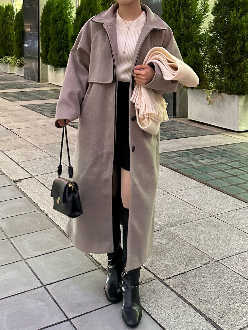ブラック系のその他パンツ、ブラック系のブーツ、ブラウン系のステンカラーコートを着用したレディースの秋コーディネートの4枚目の写真