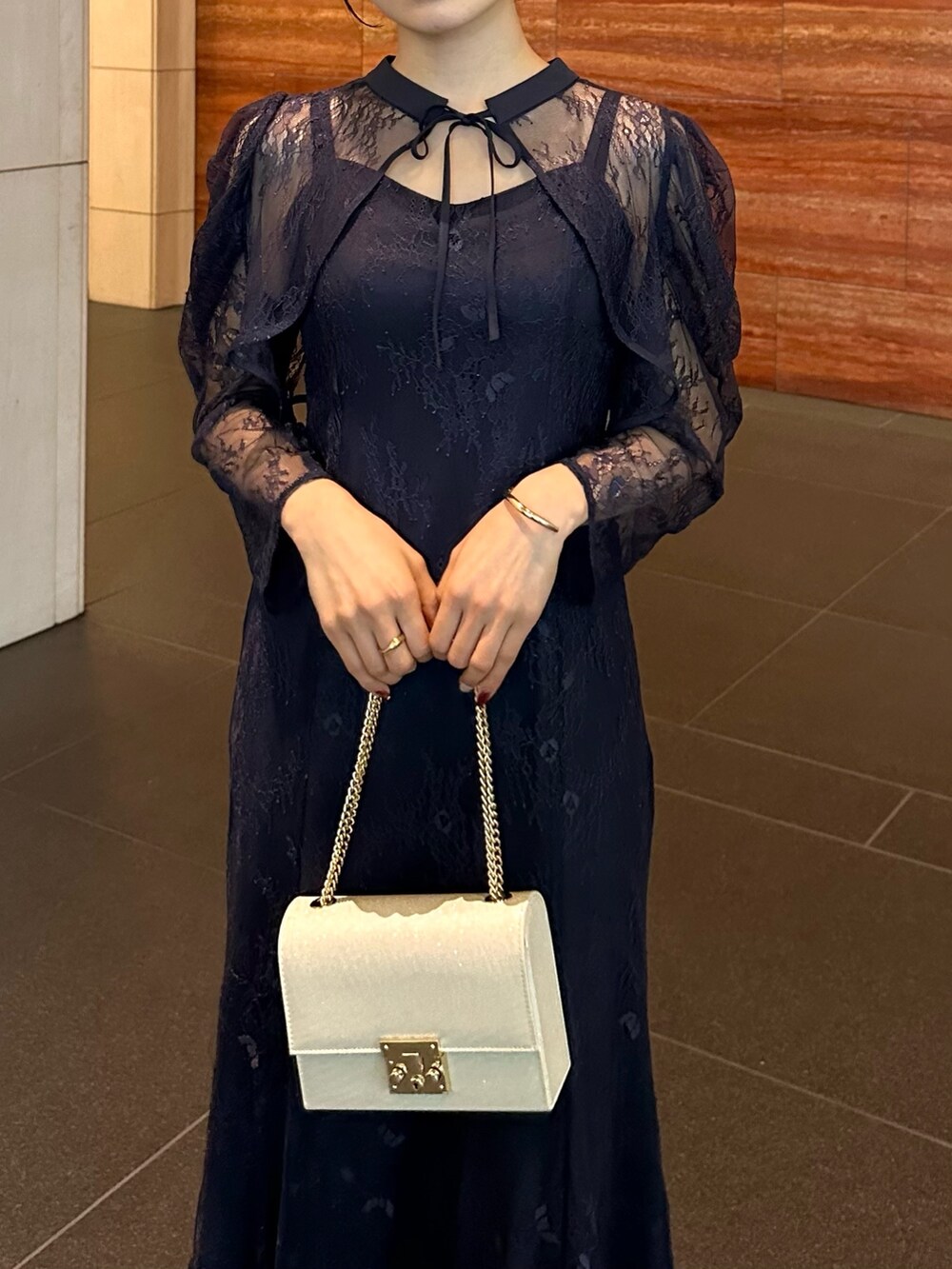 ブルー系のドレス、ベージュ系のパンプス、ベージュ系のハンドバッグを着用したレディースの冬コーディネートの4枚目の写真