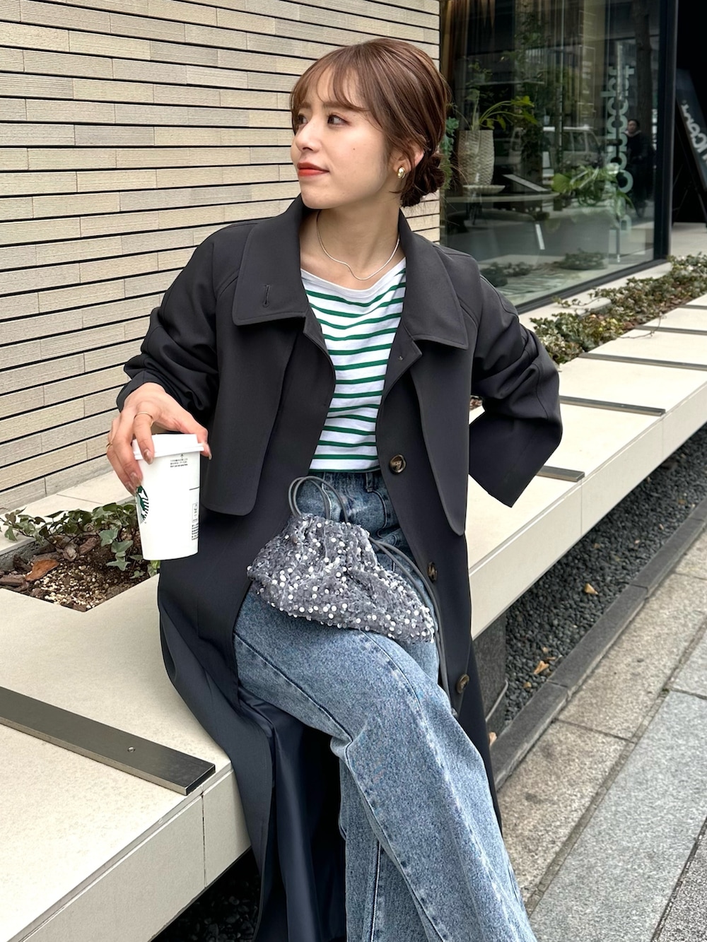 ブルー系のデニムパンツ、グレー系のトートバッグ、グレー系のステンカラーコートを着用したレディースの冬コーディネートの4枚目の写真