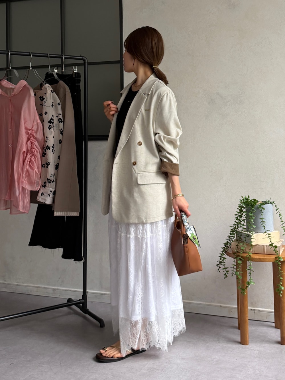 ホワイト系のスカート、ブラウン系のサンダル、ブラック系のTシャツ/カットソーを着用したレディースの春コーディネートの2枚目の写真