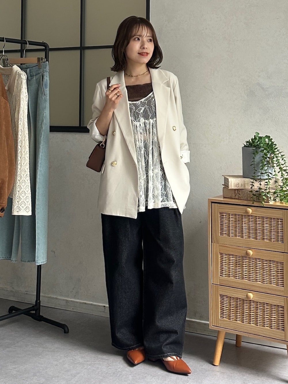 ホワイト系のテーラードジャケット、ブラック系のデニムパンツ、オレンジ系のパンプスを着用したレディースの冬コーディネートの4枚目の写真