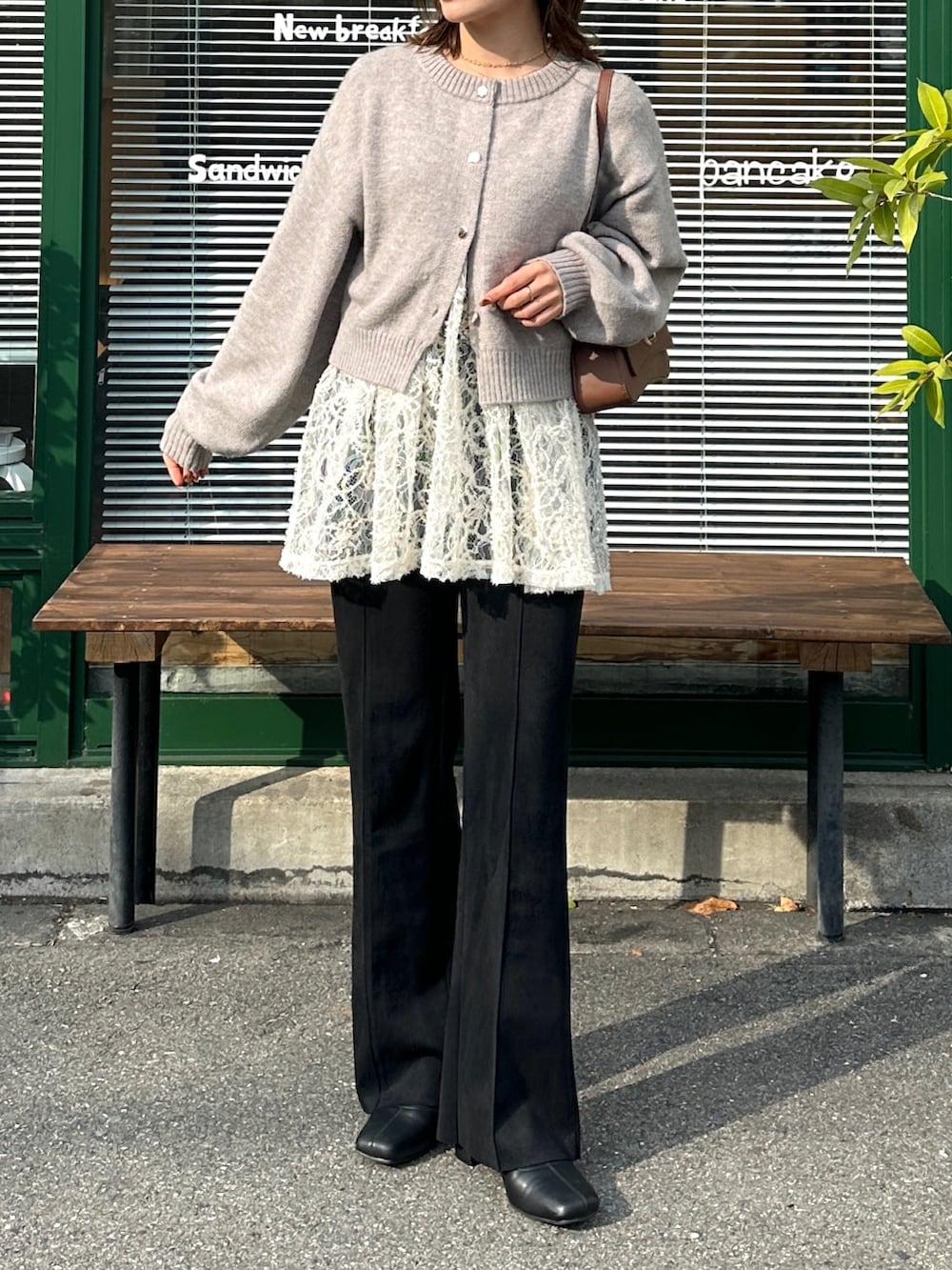 グレー系のカーディガン/ボレロ、ホワイト系のチュニック、ブラウン系のショルダーバッグを着用したレディースの冬コーディネートの5枚目の写真