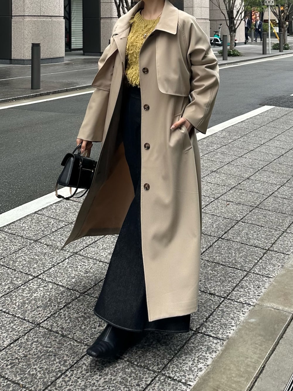 イエロー系のカーディガン/ボレロ、ベージュ系のステンカラーコートを着用したレディースの冬コーディネートの6枚目の写真