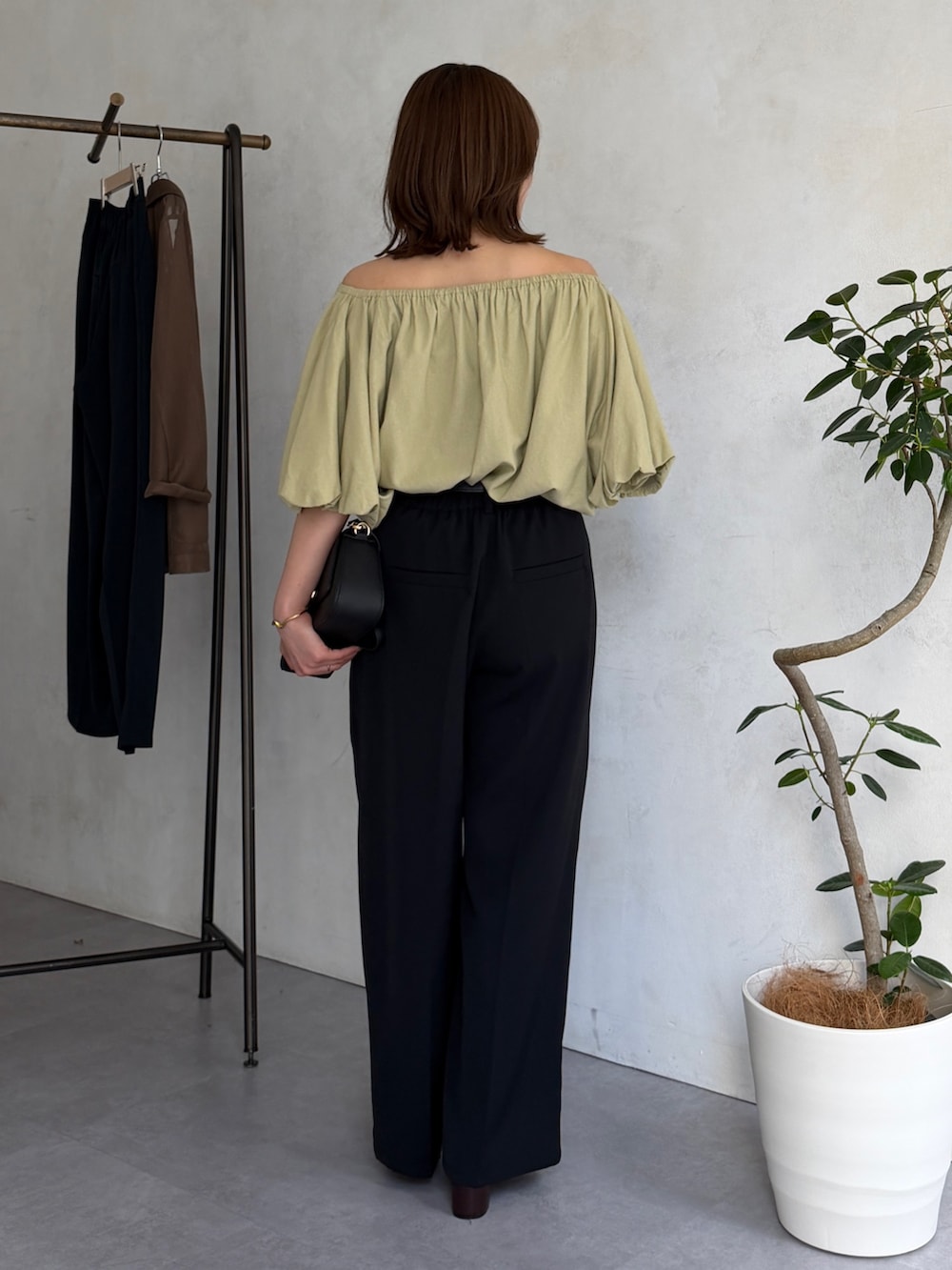 ブラック系のスラックス、イエロー系のシャツ/ブラウス、ブラウン系のパンプスを着用したレディースの春コーディネートの3枚目の写真