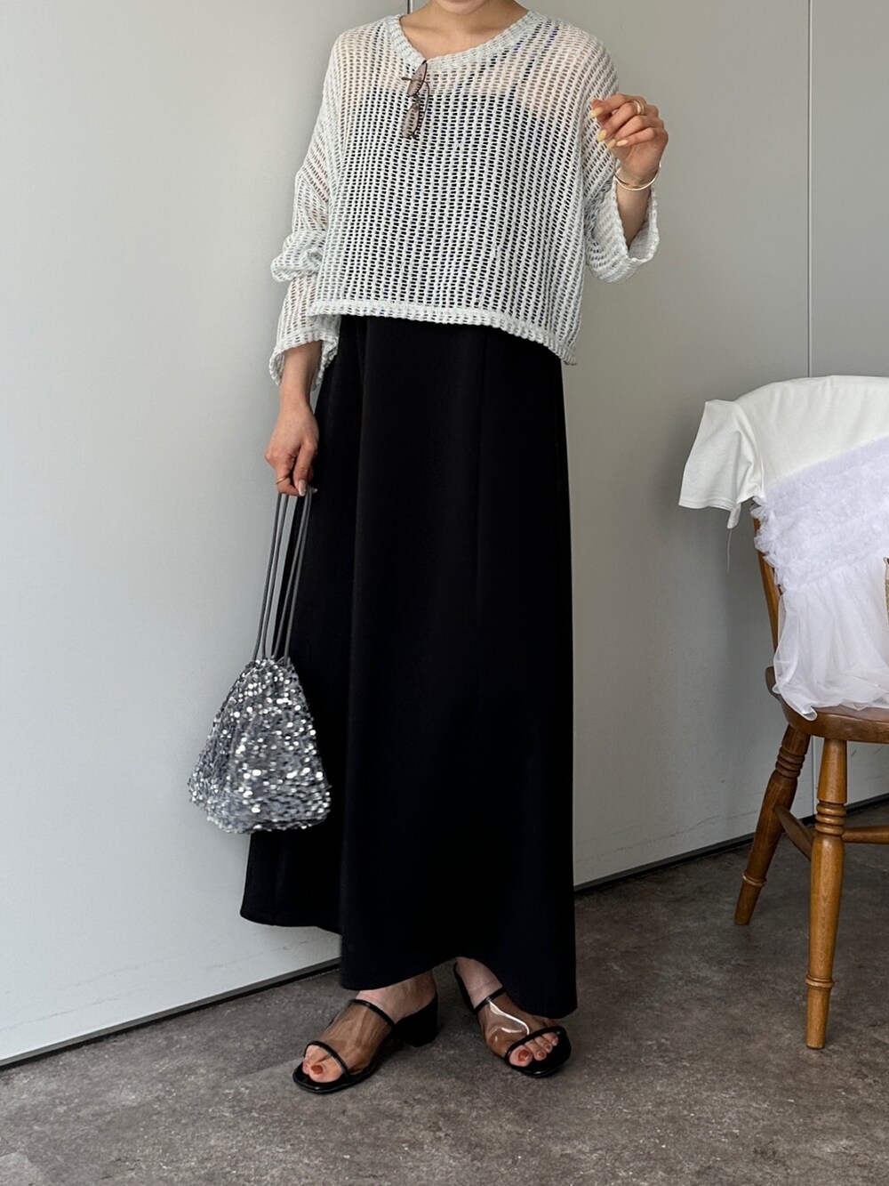 グリーン系のニット/セーター、ブラック系のサンダル、グレー系のトートバッグを着用したレディースの春コーディネートの4枚目の写真