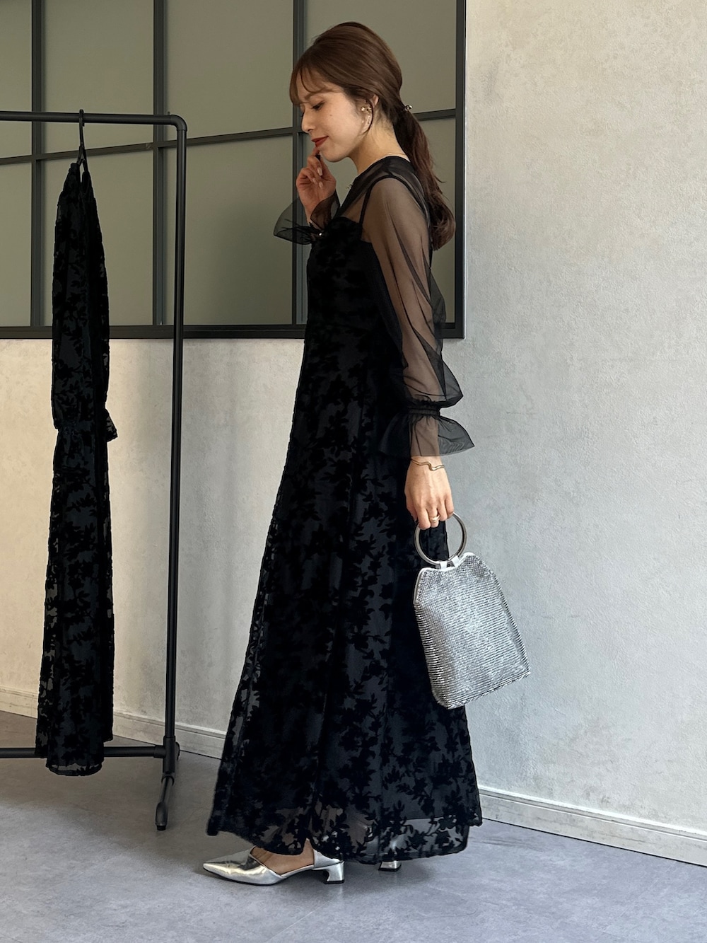 ブラック系のワンピース、シルバー系のトートバッグ、シルバー系のパンプスを着用したレディースの冬コーディネートの3枚目の写真
