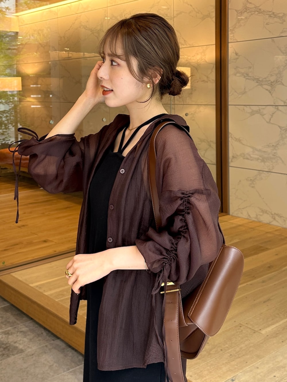 ブラック系のワンピース、ブラウン系のシャツ/ブラウス、ブラウン系のショルダーバッグを着用したレディースの夏コーディネートの2枚目の写真