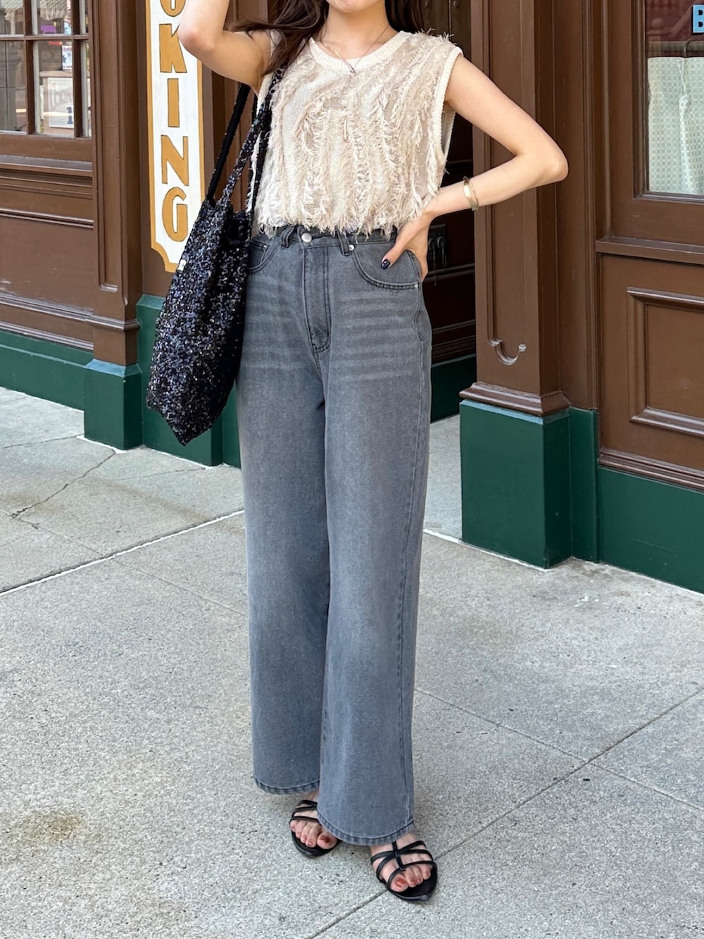 ブラック系のデニムパンツ、ホワイト系のニット/セーターを着用したレディースの春コーディネートの3枚目の写真